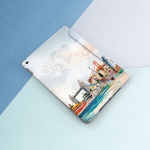 May include: A white iPad case with a watercolor design of famous landmarks in London, including Big Ben, the London Eye, and Tower Bridge. The design also includes a world map in the background.