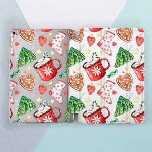 May include: A white and gray iPad case with a Christmas-themed design. The design features red mugs with marshmallows, gingerbread cookies, candy canes, and Christmas trees.
