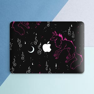 May include: Black laptop skin featuring a pink wolf design with a starry night sky theme. The design includes a white Apple logo, a crescent moon, and swirling smoke-like patterns. The wolf has pink accents.