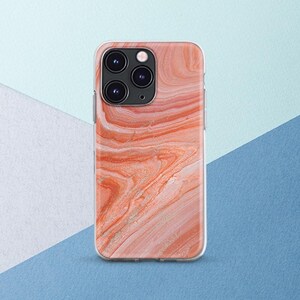 May include: A smartphone case with a swirling, abstract design in shades of peach, coral, and gold. The case has a clear border and features the camera array of a smartphone.