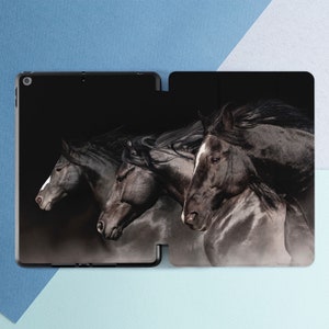 May include: Three black horses running in a dark setting. The horses have flowing manes and tails. The image is a close-up of the horses' heads and necks.