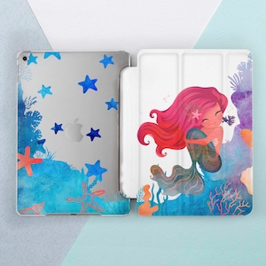 Op de afbeelding: Een witte iPad-hoes met een zeemeermin-illustratie. De zeemeermin heeft lang roze haar en een blauwe staart. De achtergrond is een aquarelontwerp in de kleuren blauw, roze en oranje. De hoes heeft een transparante achterkant met blauwe sterren.