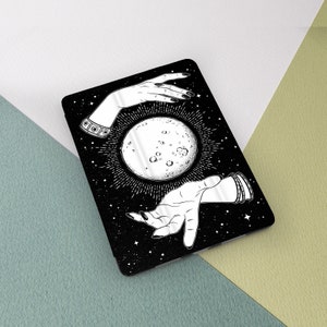 May include: A black and white illustration of two hands reaching towards a full moon with a starry background.