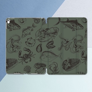 May include: A green iPad case with a repeating pattern of black and white illustrations of seafood, including fish, lobster, octopus, and crab.