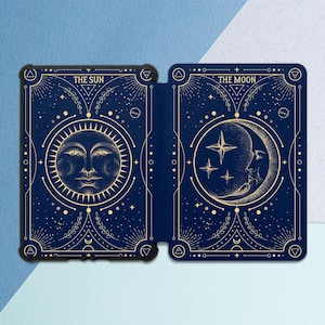 Könnte beinhalten: Eine marineblaue Hülle mit Tarotkarten-Illustrationen. Die linke Seite zeigt "THE SUN" mit einer Sonne, die rechte Seite "THE MOON" mit Mond und Sternen. Goldfarbene Details und dekorative Elemente sind vorhanden.
