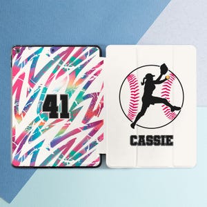 May include: An iPad case with a colorful abstract design and the number 41. The other side features a softball player silhouette inside a baseball with the name "CASSIE" below.