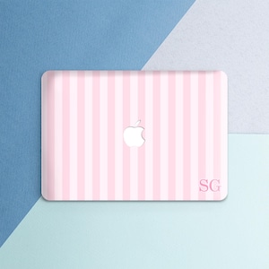 May include: A protective laptop hard shell case featuring a vertical light pink and white striped pattern. The center displays a cutout for the Apple logo, and the bottom right corner features the personalized monogram letters SG in a serif font.
