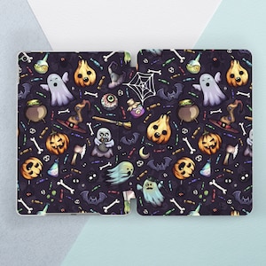 May include: A black and purple iPad case with a Halloween-themed pattern. The pattern includes ghosts, pumpkins, bats, candy corn, and other spooky elements.