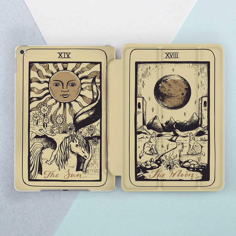 K&ouml;nnte beinhalten: Eine beige iPad-H&uuml;lle mit einem geteilten Design, das zwei Tarotkarten zeigt. Die linke Seite zeigt die Karte der Sonne mit einer Sonne, einem Kind, das ein wei&szlig;es Pferd reitet, und dem Text "The Sun". Die rechte Seite zeigt die Karte des Mondes mit einem Halbmond, zwei W&ouml;lfen und dem Text "The Moon".