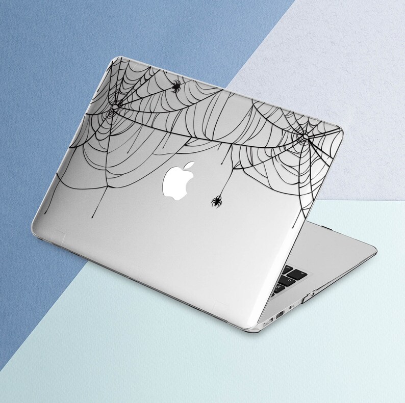 May include: A silver laptop with a black spiderweb design on the lid. The design features several small spiders.
