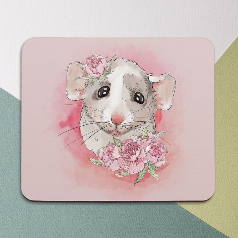 May include: A white and gray mouse with pink flowers on its head and around its neck. The mouse is looking at the viewer with a sweet expression. The background is a soft pink watercolor wash.