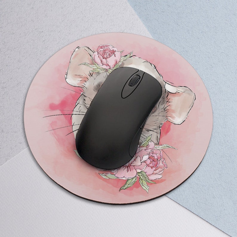 May include: A pink and white round mouse pad with a watercolor illustration of a chinchilla with pink flowers. A black computer mouse is on top of the mouse pad.