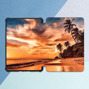 May include: A tablet case featuring a vibrant beach scene at sunset. The image shows a sandy beach, palm trees, and a colorful sky with shades of orange, yellow, and blue. The case has a black border.