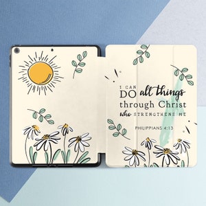 May include: A white and cream iPad case with a floral design and a quote from Philippians 4:13, "I can do all things through Christ who strengthens me".