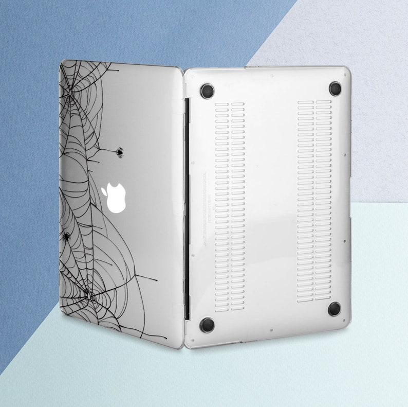 May include: A white laptop case with a black spiderweb design. The case has a clear back and a black design on the front.