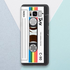 May include: A black and white phone case with a colourful cassette tape design. The case has the text "TAPE" and "C-90" printed on it. The case is designed to look like a vintage cassette tape.