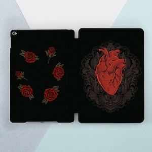 May include: Black phone case with a red anatomical heart illustration surrounded by a floral design. The back of the case has a pattern of red roses.