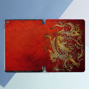 May include: Red leather iPad case with a gold dragon design. The dragon is intricate and detailed, with swirling patterns and a textured background.