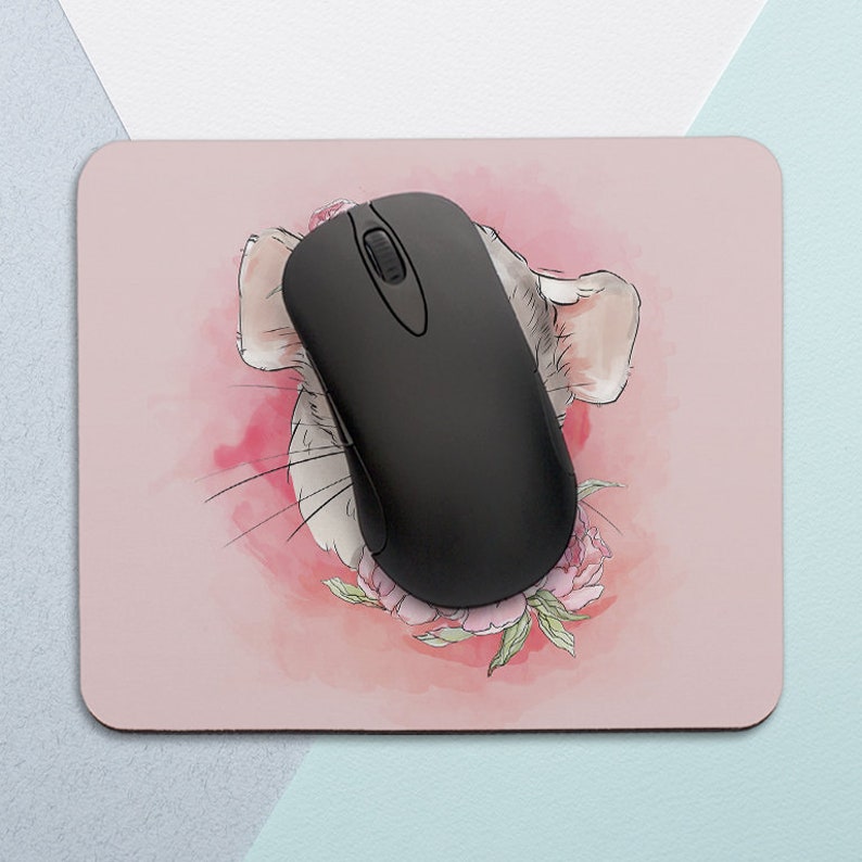 May include: A pink mouse pad with a watercolor illustration of a chinchilla's face with pink flowers. A black computer mouse is on top of the pad.