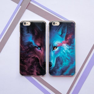 May include: Two phone cases with a galaxy and wolf design. The left case features a red wolf with blue eyes and the right case features a blue wolf with orange eyes.