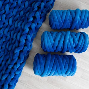 A soft, handmade chunky knit blanket crafted from plush velvet yarn. This giant knit throw blanket adds warmth and texture to any living space, perfect for home décor, bedding, or gifting.