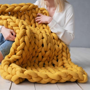 Peut inclure: Une grande couverture en tricot &eacute;pais de couleur jaune moutarde. La couverture est faite de fil &eacute;pais et doux et a une sensation d&eacute;tendue et confortable.