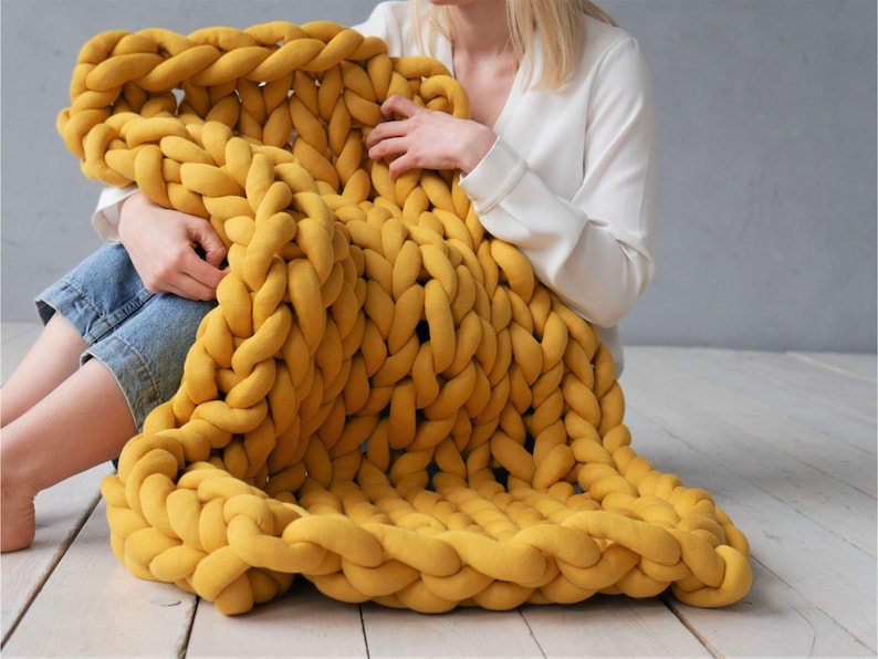 Peut inclure: Une grande couverture en tricot &eacute;pais de couleur jaune moutarde. La couverture est faite de fil &eacute;pais et doux et a une sensation d&eacute;tendue et confortable.