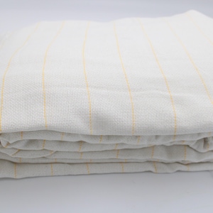 May include: Folded white fabric with vertical yellow stripes. The fabric appears to be a woven material, possibly linen or cotton. The stripes are evenly spaced and add a subtle design element to the textile.