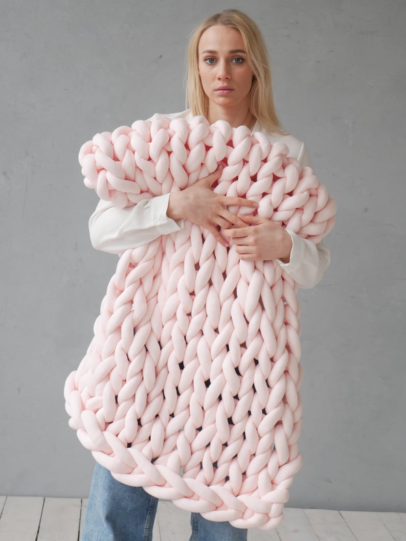 Peut inclure: Une grande couverture en tricot &eacute;pais de couleur rose p&acirc;le. La couverture est faite de fil &eacute;pais et a une texture douce et moelleuse.