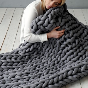 Girl is holding a weighted blanket. Handmade cotton weighted chunky knit blanket – perfect for PTSD, fibromyalgia, anxiety, ADHD, and sensory needs. It is a cotton weighted blanket - does not have glass beads. It is a handmade knit from cotton tube yarn, blanket is made by the weight that you need, from the cotton yarn amount that you need.