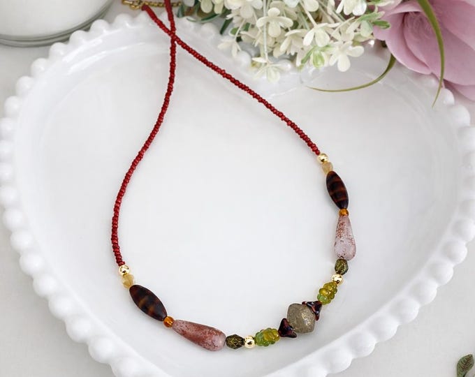 Collier avec Des verts doux associés à des bruns chaleureux composent une palette naturelle et apaisante