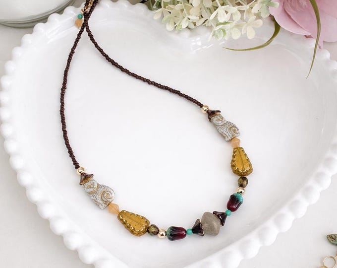 Collier avec Des verts doux associés à des bruns chaleureux composent une palette naturelle et apaisante