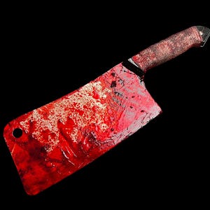 May include: A large, red-stained butcher knife with a black handle. The blade is covered in blood.