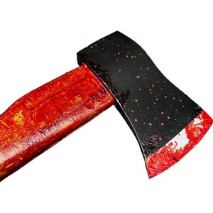 K&ouml;nnte beinhalten: Eine schwarze Axt mit einem rot lackierten Holzstiel. Der Axtkopf hat rote Spritzer.