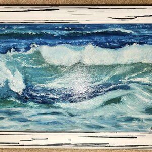 Puede incluir: Pintura al óleo de olas oceánicas en tonos azules y turquesas, enmarcada en un marco de madera blanca envejecida. La obra representa el movimiento del agua con pinceladas visibles, capturando la esencia del mar.