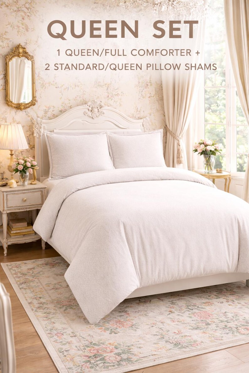 Puede incluir: Un juego de cama tama&ntilde;o queen con un edred&oacute;n y dos fundas de almohada. La ropa de cama es de color claro y neutro. La escena incluye una alfombra floral, una mesita de noche y un espejo decorativo. El texto "QUEEN SET" es visible.