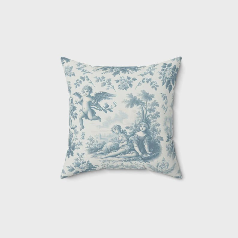 Puede incluir: Coj&iacute;n cuadrado con un estampado toile de Jouy azul y blanco. El dise&ntilde;o presenta querubines, &aacute;rboles y elementos florales. El coj&iacute;n tiene un aspecto suave y acogedor, adecuado para la decoraci&oacute;n del hogar.