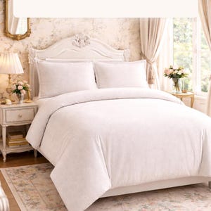 Puede incluir: Un juego de cama tama&ntilde;o king con un edred&oacute;n y dos fundas de almohada. La ropa de cama es de color claro con un patr&oacute;n sutil. El texto en la parte superior dice "KING SET" e incluye el n&uacute;mero de piezas.
