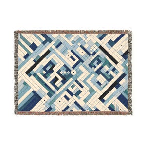 May include: A woven throw blanket with a geometric pattern in shades of blue, green, and white. The pattern is made up of squares and rectangles, and it creates a modern and abstract design.