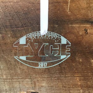 Pu&ograve; includere: Un ornamento di vetro bianco a forma di pallone da calcio con il nome "Tyce" e l'anno "2017" incisi su di esso.