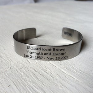 May include: A silver metal bracelet with an engraved message: "Richard Kent Brown "Strength and Honor" Jan 21 1937 - Nov 23 2007"