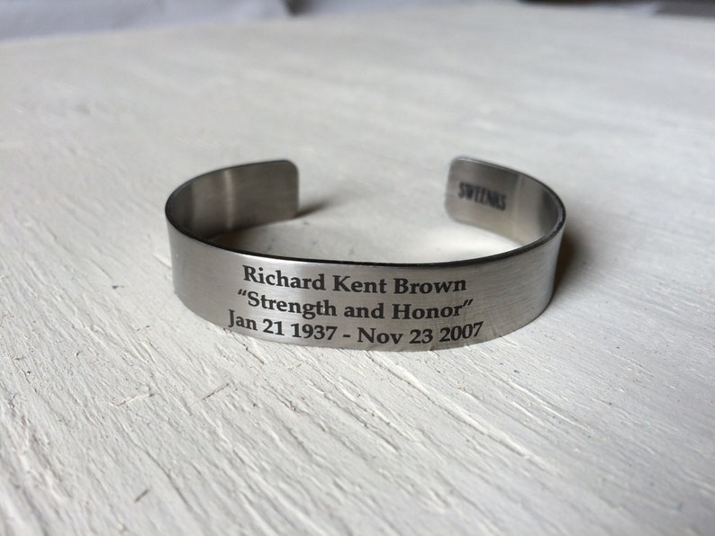 May include: A silver metal bracelet with an engraved message: "Richard Kent Brown "Strength and Honor" Jan 21 1937 - Nov 23 2007"