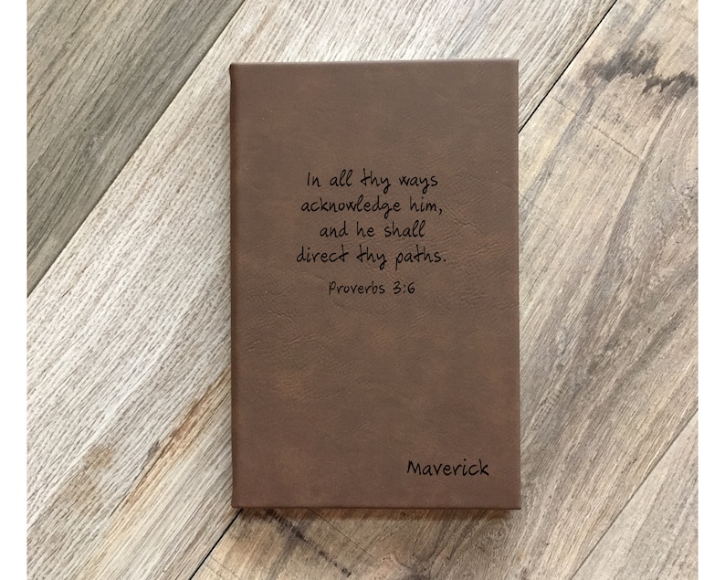 May include: A brown leather journal with the inscription "In all thy ways acknowledge him, and he shall direct thy paths. Proverbs 3:6" and the name "Maverick" on the bottom.