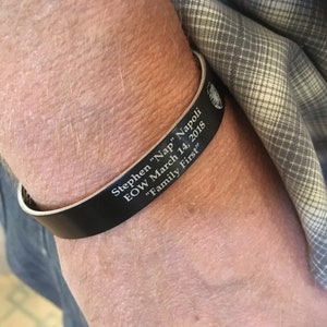 May include: Black leather bracelet with the inscription "Stephen "Nap" Napoli EOW March 14, 2018 "Family First"