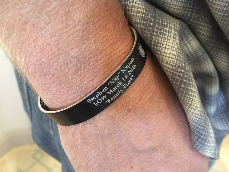 May include: Black leather bracelet with the inscription "Stephen "Nap" Napoli EOW March 14, 2018 "Family First"