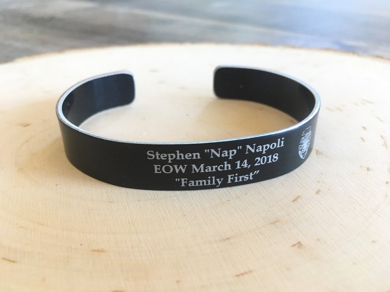 May include: Black metal bracelet with an engraved inscription: "Stephen "Nap" Napoli EOW March 14, 2018 "Family First"