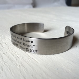 May include: Silver metal bracelet with an engraved message: "Richard Kent Brown Strength and Honor" 02 1937 - Nov 23 2007.