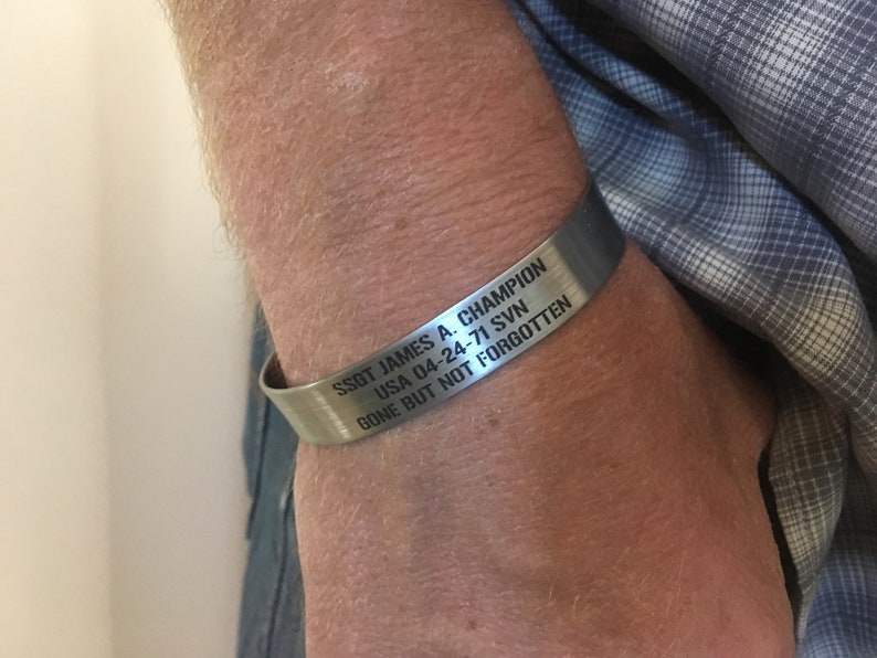 May include: A silver bracelet with the inscription "SSGT JAMES A. CHAMPION USA 04-24-71 SVN GONE BUT NOT FORGOTTEN".