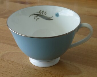 Xícara de chá vintage Royal Doulton Caprice ~ Copa com pés ~ Flores azuis ~ Azul claro com uma faixa prateada