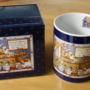 May include: A blue and white ceramic mug with a farmhouse scene and the text "Within this House, we love all those who warm our hearts". The mug is packaged in a blue box with red hearts.